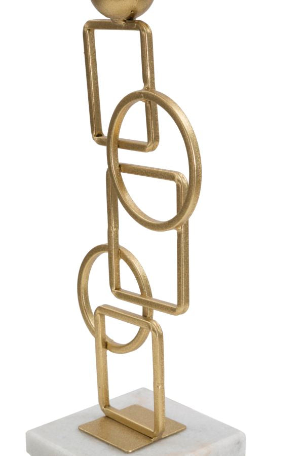 Geometrischer Kerzenständer aus Goldmetall auf weißem Marmorsockel