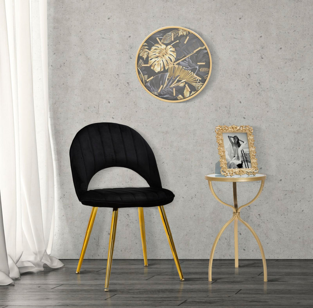 Goldene und graue Wanduhr mit tropischem Blattmuster
